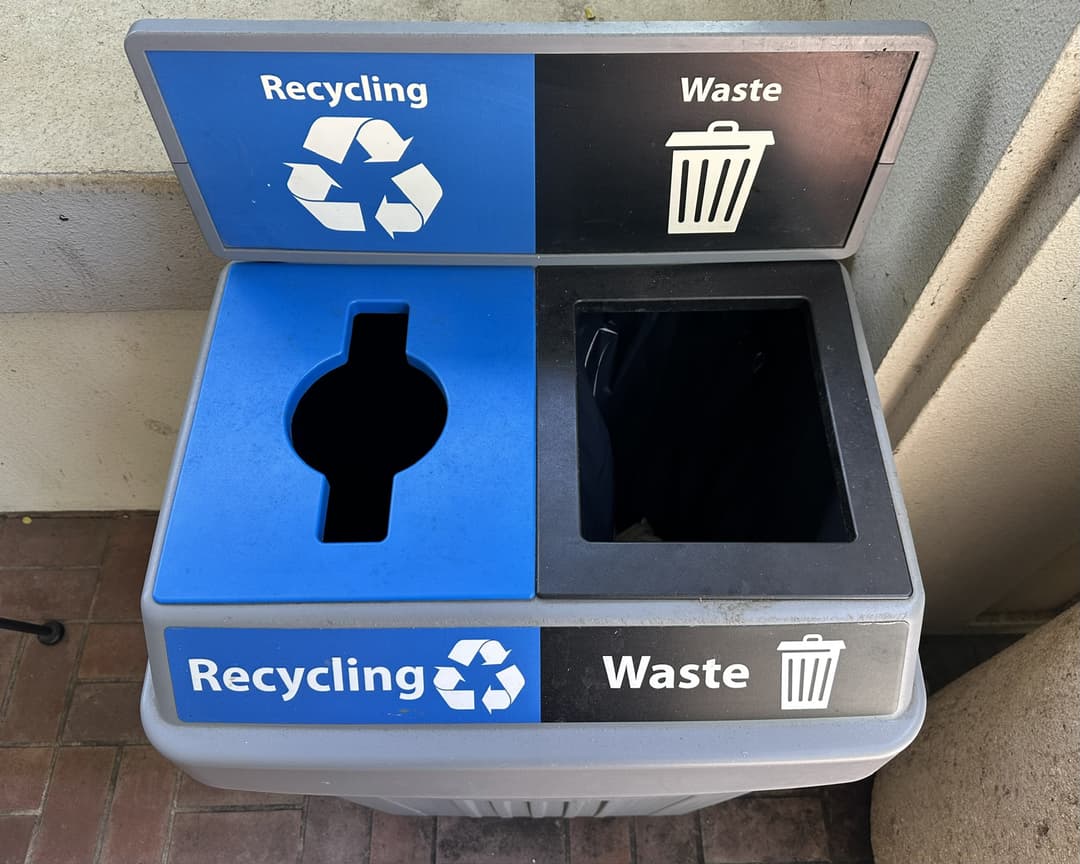Campus recycling bin with separate openings for recyclables and waste
